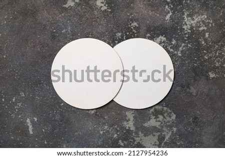 Blank white beer coasters on concrete background. Responsive design mockup. Flat lay.