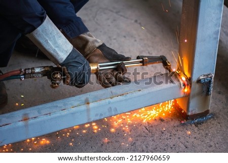 Welding, gases and oxygen to weld and cut metals. content safety accessories. Metal cutting, steel with acetylene torch in factory. wear protective gloves when working with fire flakes Royalty-Free Stock Photo #2127960659