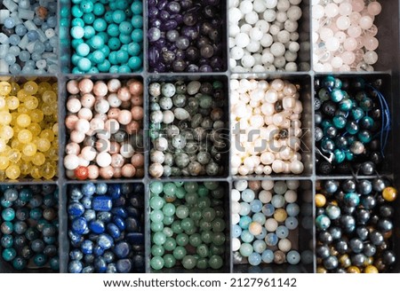 Selective focus. assortment of multi-colored natural stones in the organizer. stones for handmade jewelry and bracelets