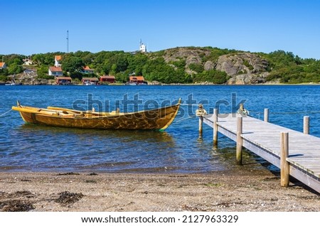Single rowboat at a landing stage on the North shore of the South Koster Island (Sydkoster) with a beautiful view of the North Koster Island (Nordkoster), Bohuslän, Västra Götalands län, Sweden. Royalty-Free Stock Photo #2127963329