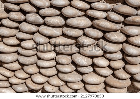 Wall is made of pebbles closeup. Stone background.