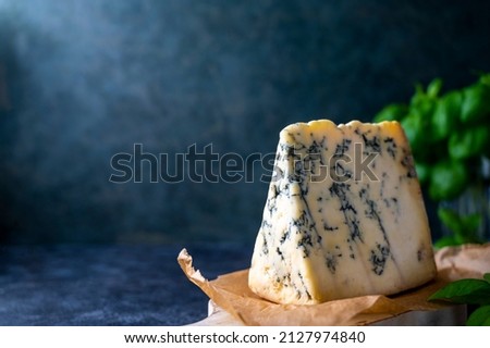 Blue cheese, dor blue or roquefort mold cheese slice on cutting board with basil leaves, lifestyle food Royalty-Free Stock Photo #2127974840