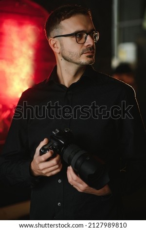 Portrait of photographer holding digital camera