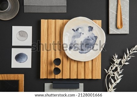 Elegant flat lay composition of interior designer moodboard with textile and paint samples, lamella panel and tiles. Black, beige and grey color palette. Copy space. Template.
