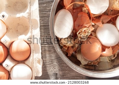 Prepare to paint the egg for Easter. Onion husks, egg and towel are on a wooden table