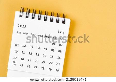 The July 2022 desk calendar on light yellow background. Royalty-Free Stock Photo #2128013471