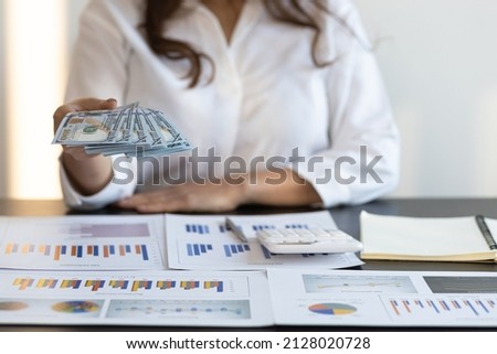 Woman holding money and banknotes, cash is offering to you. Wage payment concept.