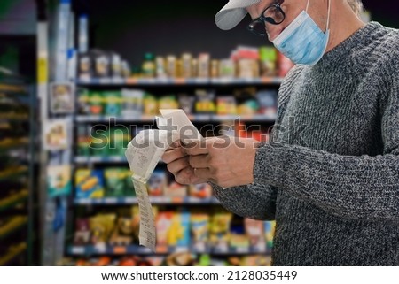 Man in face mask shopping in grocery department store during coronavirus crisis Royalty-Free Stock Photo #2128035449