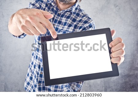 Casual man pointing to 10 inch display of digital tablet computer as copy space for your message or design. Royalty-Free Stock Photo #212803960