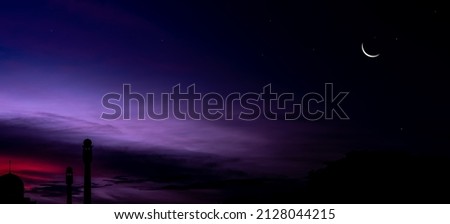 Concept the crescent moon the symbol of Islam begins the eid al Fitr. Seeing the moon in the night sky. The evening sky and the vast river in darkness are beautiful. Royalty-Free Stock Photo #2128044215