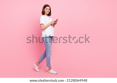 Full length body size view of attractive cheerful girl going using gadget web smm media multimedia isolated over pink pastel color background Royalty-Free Stock Photo #2128064948