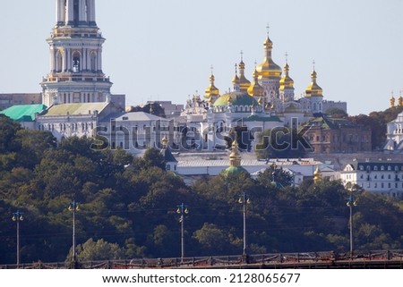 Bright evening cityscape of the big city on the hill over wide river Dnipro in awesome bright sunset in Kyiv, Ukraine. View at Kyiv-Pechersk Lavra National Reserve.