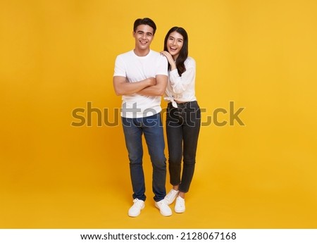 Young attractive Asian couple man and woman happy and hugging on yellow background. Concept for love photography.