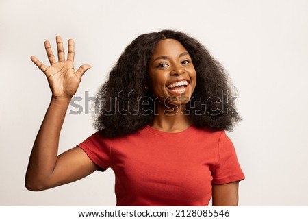 Hello. Portrait Of Joyful Young Black Woman Waving Hand At Camera, Cheerful Excited African American Female Gesturing Hi, Greeting Somebody While Standing Over White Studio Background, Copy Space Royalty-Free Stock Photo #2128085546