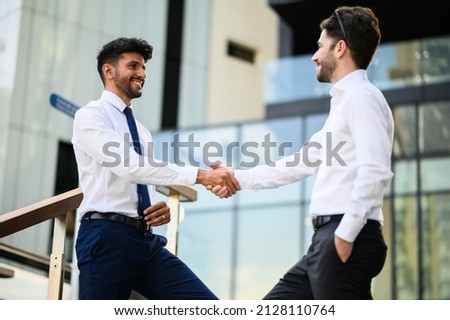 Two managers having a handshake outdoor in a modern setting