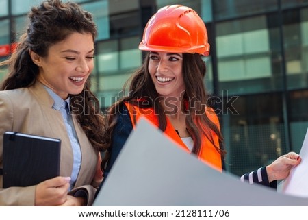 Engineers examining plans on construction site to client. Business woman looking at a plan.
