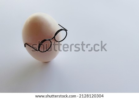White shell egg wear glasses on white background with copy space for text