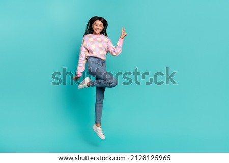 Full length body size view of attractive cheery funny girl jumping showing v-sign good mood isolated on shine teal turquoise color background