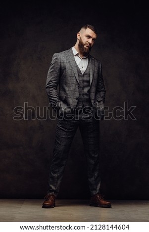 Brutal businessman gentleman in a suit poses in the studio