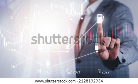 Oil energy graph of the world market, impact on the economy concept, Businessman touch chart with the indicator on the oil price slide at gas station, fluctuations in oil prices and exchange trade. Royalty-Free Stock Photo #2128192934