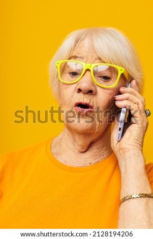smiling elderly woman in casual t-shirt communication by phone close-up emotions