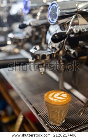 ้hot coffee latte on espresso machine in background