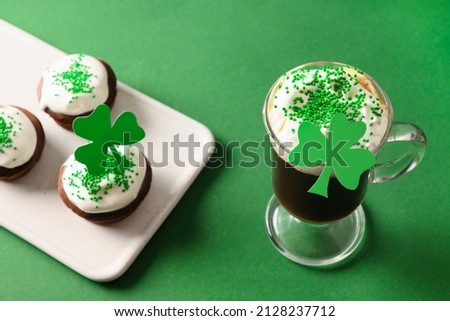 Irish coffee and special cupcakes for Happy St Patricks Day on green background. Close up. Festive traditional food.