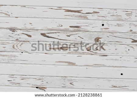 Fence made of wooden plank, painted with white paint, exposed to the weather. Textural composition
