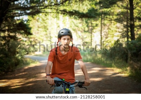 happy teen boy riding a bike on natural background, forest or park. healthy lifestyle, family day out. High quality photo