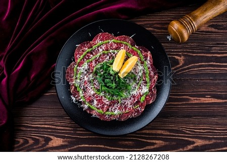 Carpaccio of beef on a plate with mustard and spices, beef carpaccio with parmesan and lemon Royalty-Free Stock Photo #2128267208