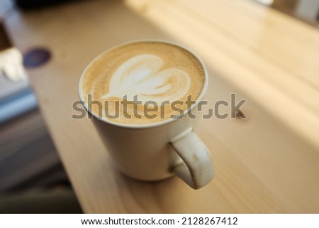 A closeup shot of a latte with a heart in a coffee shop