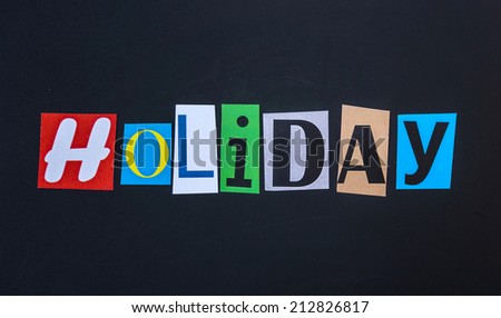 The word holiday in cut out magazine letters on blackboard