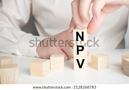 businesswoman holding wooden block with text Net present value. NPV , business concept