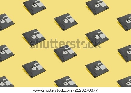 Seamless pattern made of vintage floppy disk drive on bright yellow background. Minimal and abstract concept. Nostalgic 80s and 90s concept.