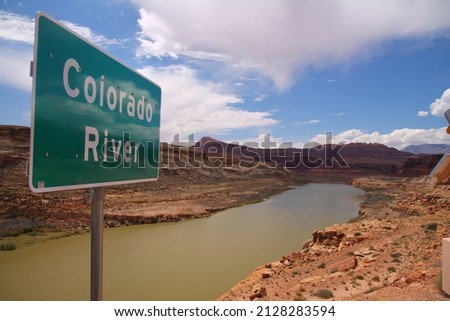 A green road sign indicating the Colorado River crossing below the bridge in Utah Royalty-Free Stock Photo #2128283594
