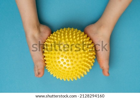 children's feet with a yellow balancer on a light blue background, treatment and prevention of flat feet, valgus deformity of the foot