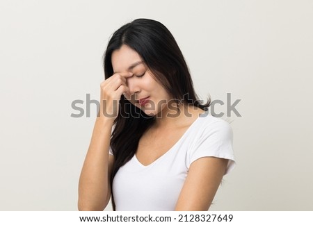 Young asian beautiful woman hand rubbing eyes she's feeling depressed stress headache be tired from working standing on isolated white background she has health problems. Royalty-Free Stock Photo #2128327649
