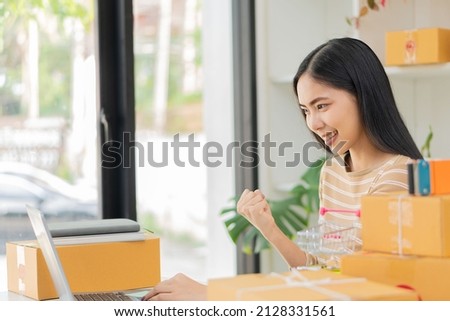 Asian woman working at the home online box with the laptop to take orders from customers, sme parcel delivery business start-up idea.
