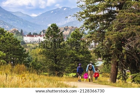 Three generations of family hiking near Estes Park, Colorado, in summer; building and mountains in background Royalty-Free Stock Photo #2128366730