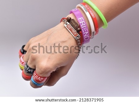 Hand full of friendship bands and ring on the occasion of friendship day with white background Royalty-Free Stock Photo #2128371905