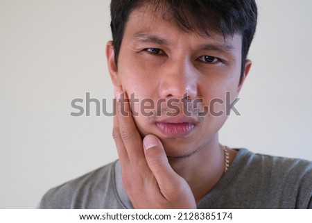 Teetch problem. Asian male with painful cheek swelling or dental abscess. A facial injury, tooth abscess, salivary stones, salivary gland tumor. Royalty-Free Stock Photo #2128385174