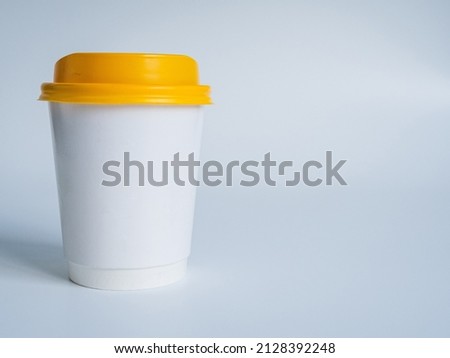 Front top view, white coffee paper cup yellow lid, filled with hot black coffee(americano), no sugar milk, ready to drink, refreshing. aroma awake fresh to work placed on a white isolated background