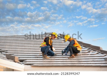 roof extension roof installation engineer roof-construction workers stand on tiled roof Royalty-Free Stock Photo #2128399247