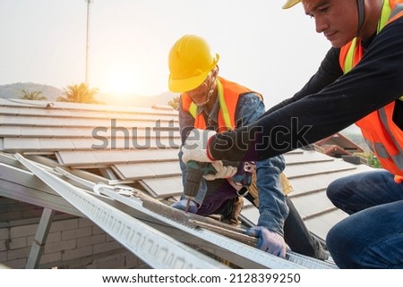 roof extension roof installation engineer roof-construction workers stand on tiled roof Royalty-Free Stock Photo #2128399250
