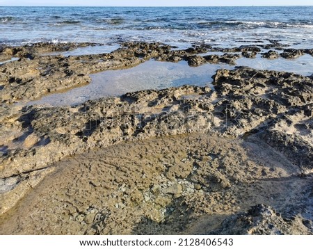 Protaras. Famagusta area. Cyprus. The coast of the Mediterranean Sea, long frozen lava, in the recesses of which water splashes.
