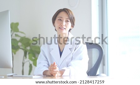 Japanese female doctor counseling indoors Royalty-Free Stock Photo #2128417259