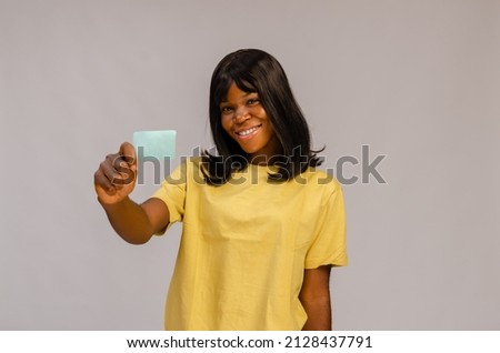 Attractive business woman holding business card in front of her, isolated on white background