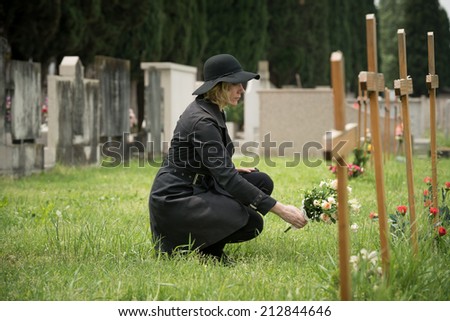 Woman at graveside with flowers