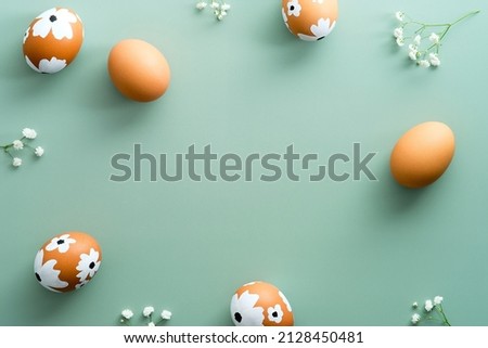 Happy Easter flat lay composition. Easter eggs with flowers on pastel green background. Easter card design, template. Royalty-Free Stock Photo #2128450481