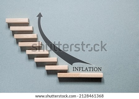 Wooden blocks in the form of staircase steps are placed on a grey background. The concept is an increase in the inflation rate. Inflation by month. Annual inflation.